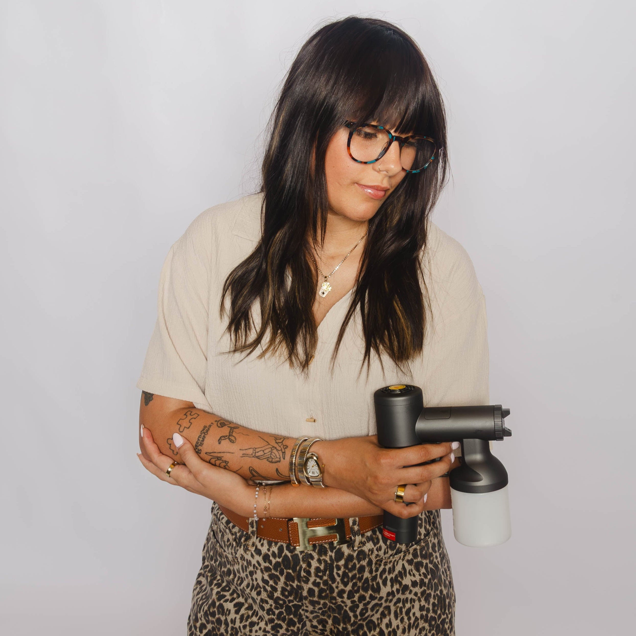 Person holding a hair dryer against a plain background